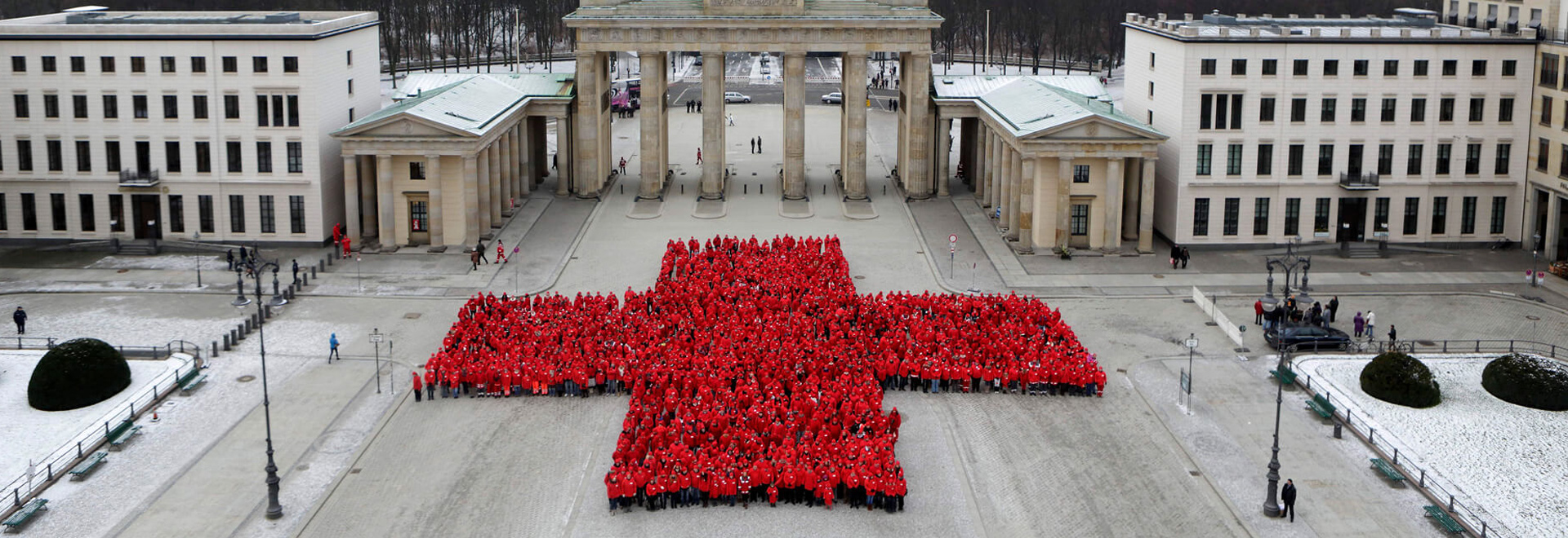 Hunderte DRK-Mitarbeiter formen ein Rotes Kreuz am Brandenburger Tor
