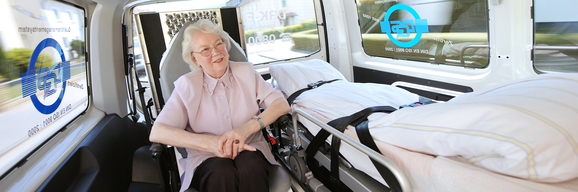 Seniorin sitzt in einem Krankenwagen