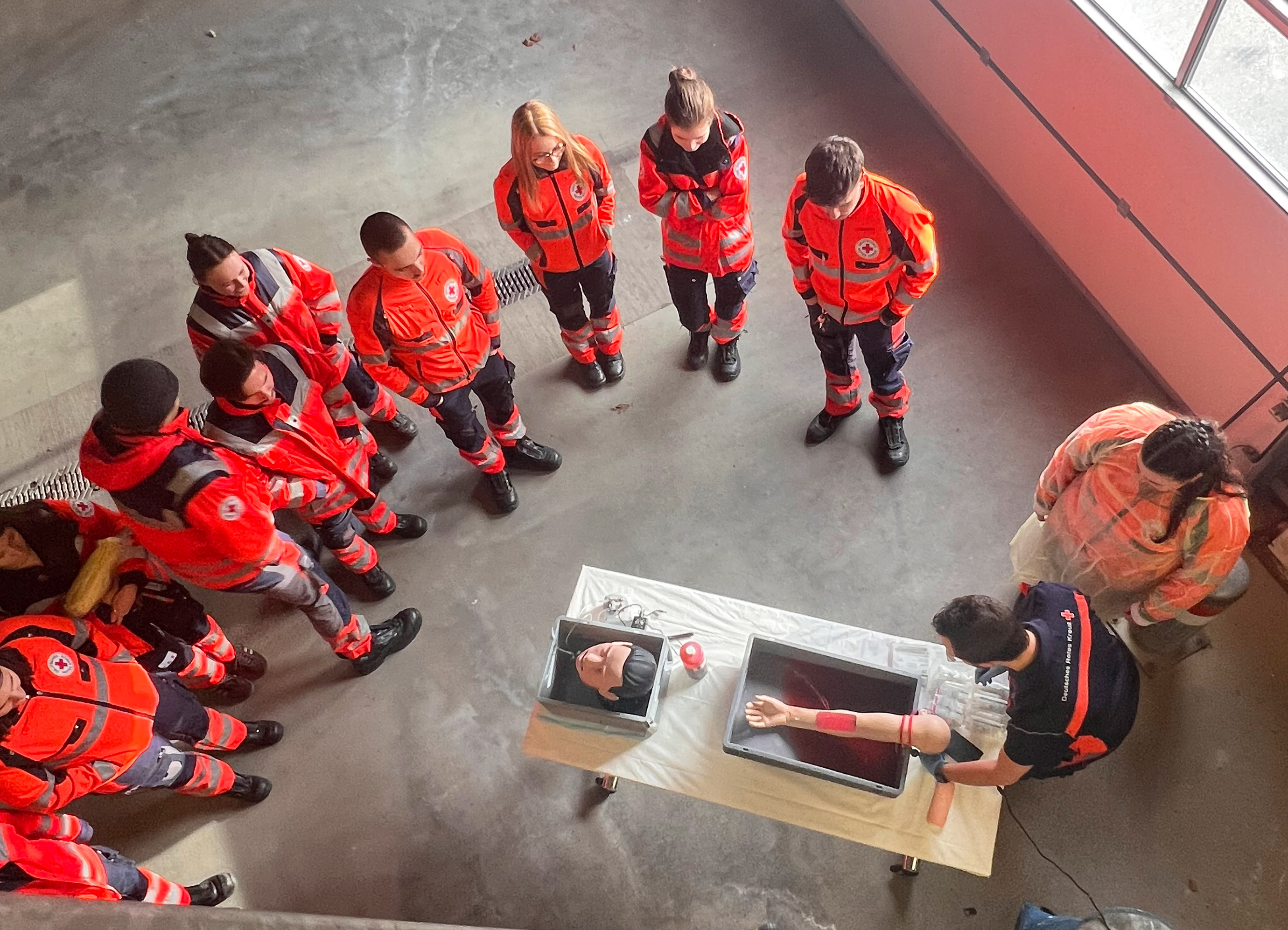 Das Foto zeigt die Auszubildenden an der Übungsstation für arterielle Blutung.liert.im Fachvortrag in unserem Schulungsraum im DRK-Zentrum für Bevölkerungsschutz.