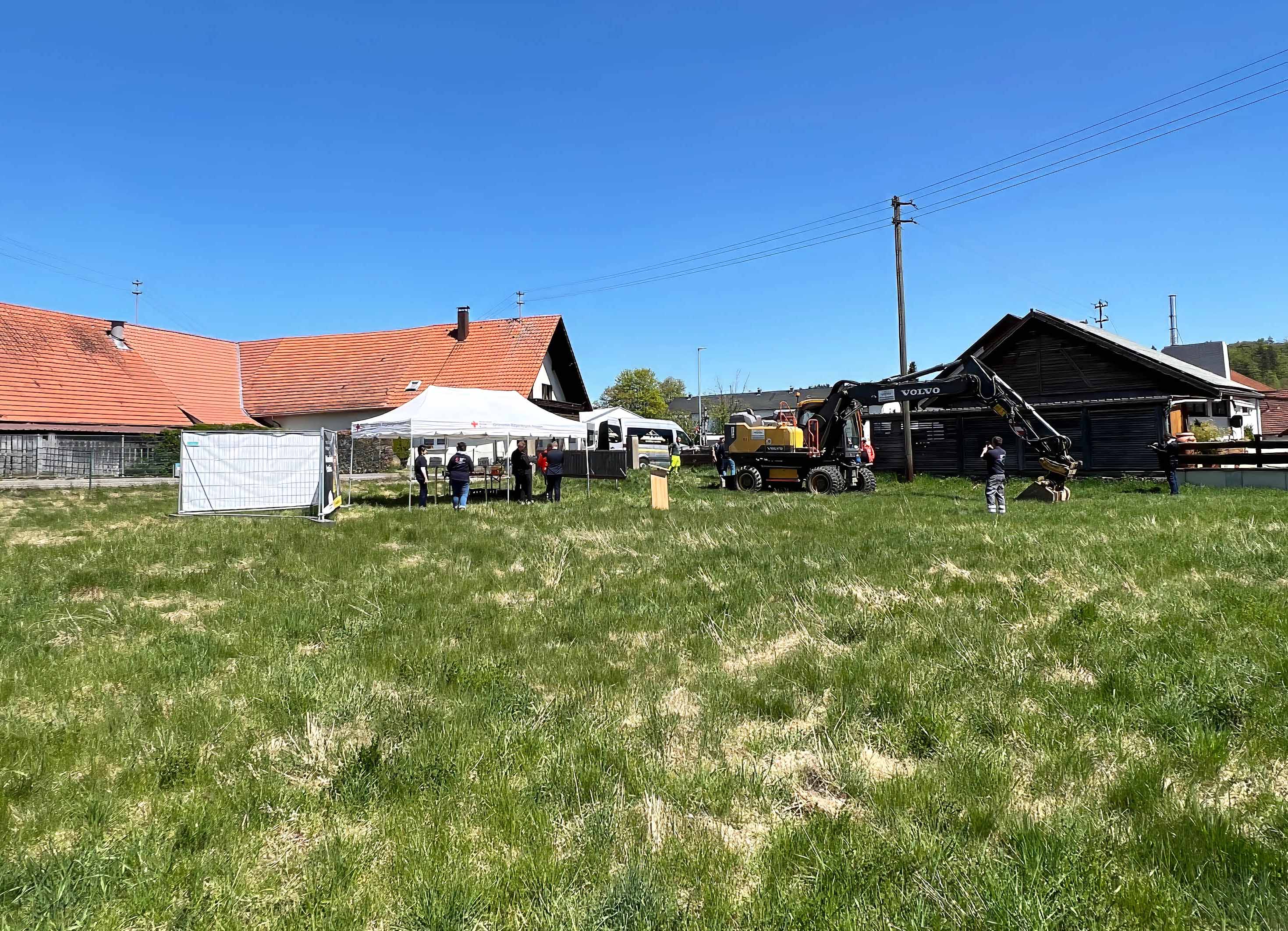 Das Bild zeigt das Baugrundstückind ehrenamtliche Helferinnen und Helfer aus den Bereitschaften Eningen und Pfullingen sowie Fahrzeuge des Bevölkerung- und Katastrophenschutzes zu sehen.