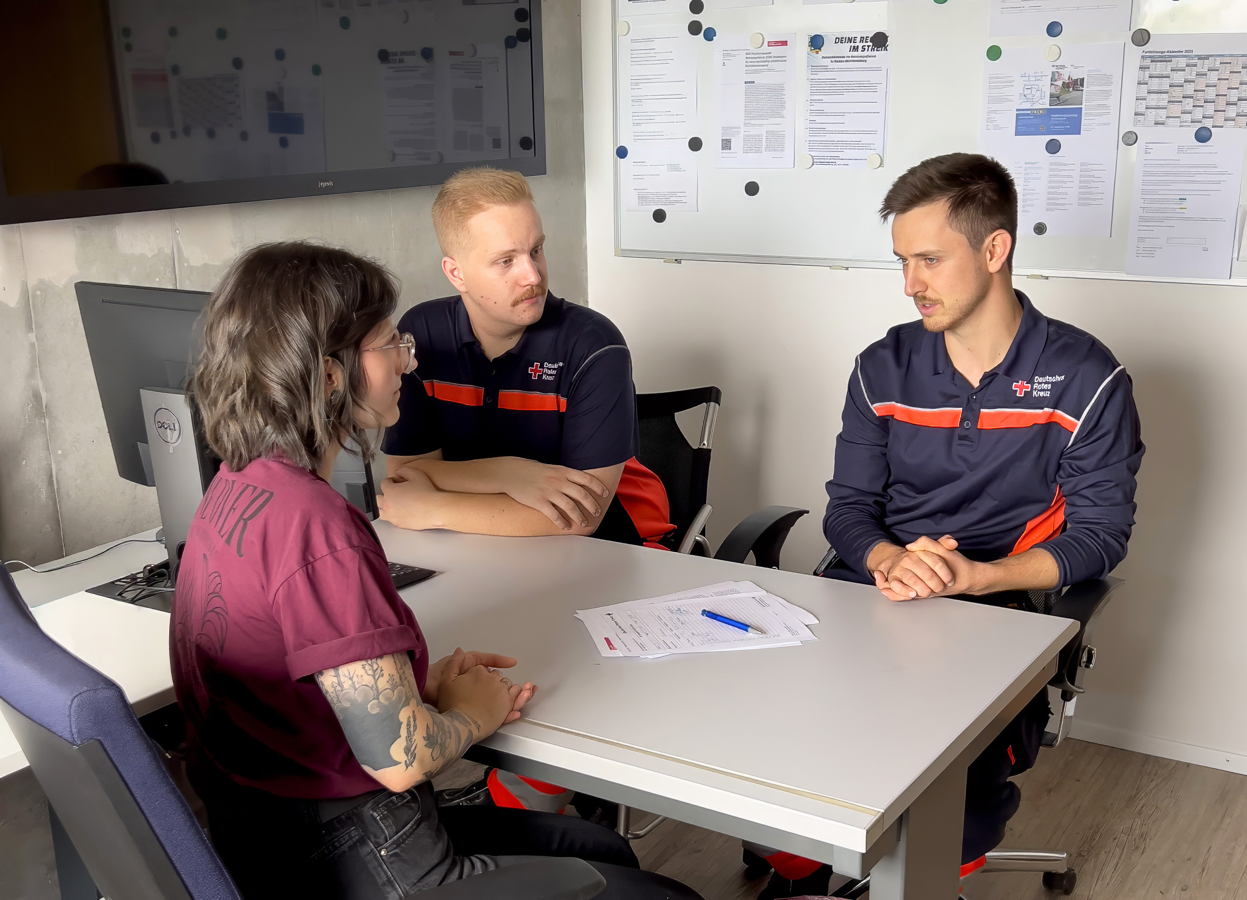 Zwei Notfallsanitäter sprechen mit einer Kollegin aus der PEER-Gruppe.