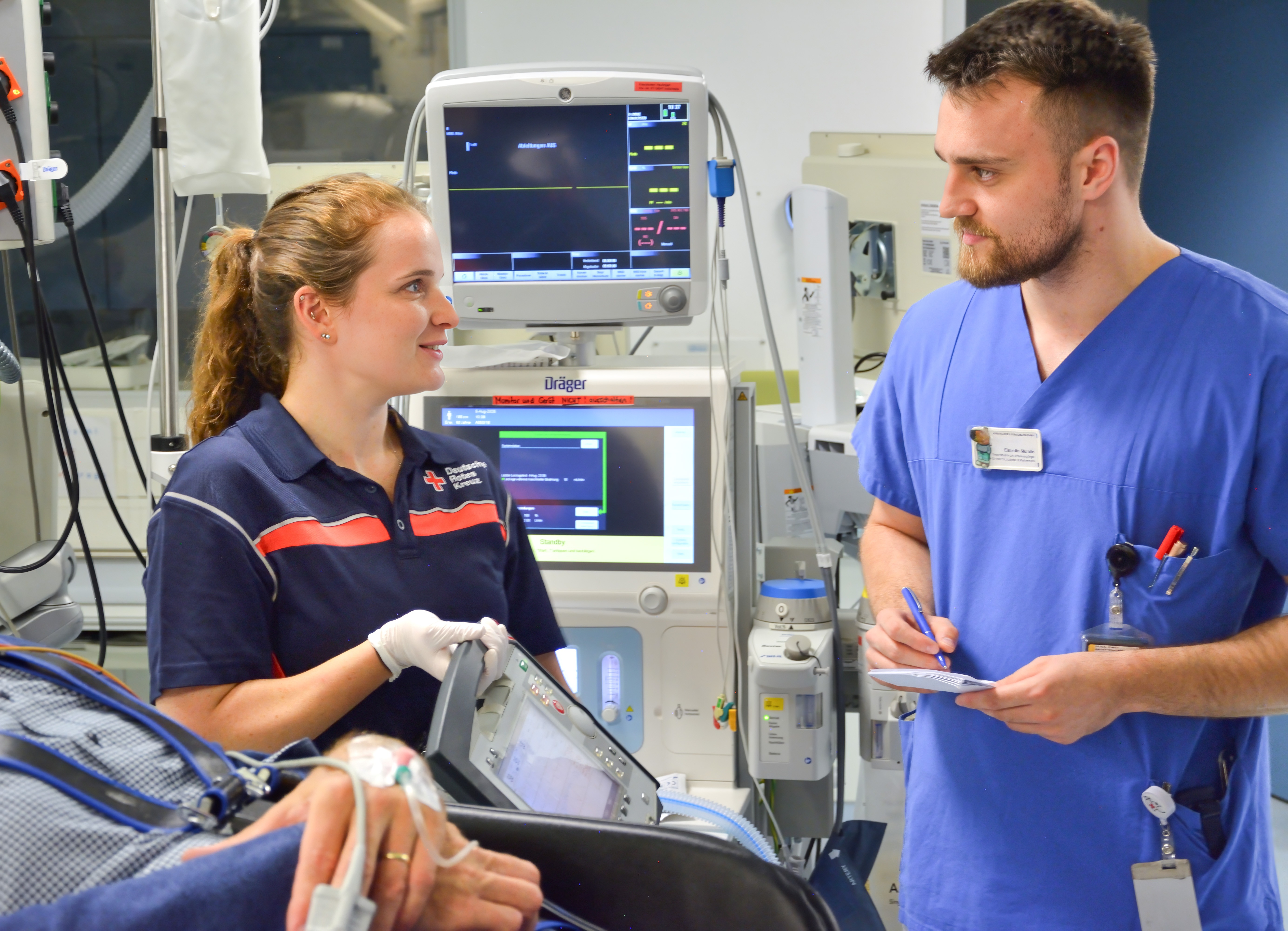 Übergabegespräch zwischen einer Notfallsanitäterin und einem Arzt im Schockraum der Kreisklinik