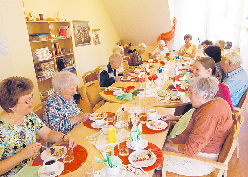 Einige Senioren gemeinsam am Tisch beim Kaffeetrinken