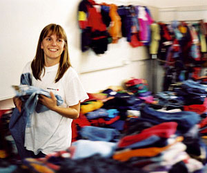 Lächelnde Frau beim Sortieren von Kleidung